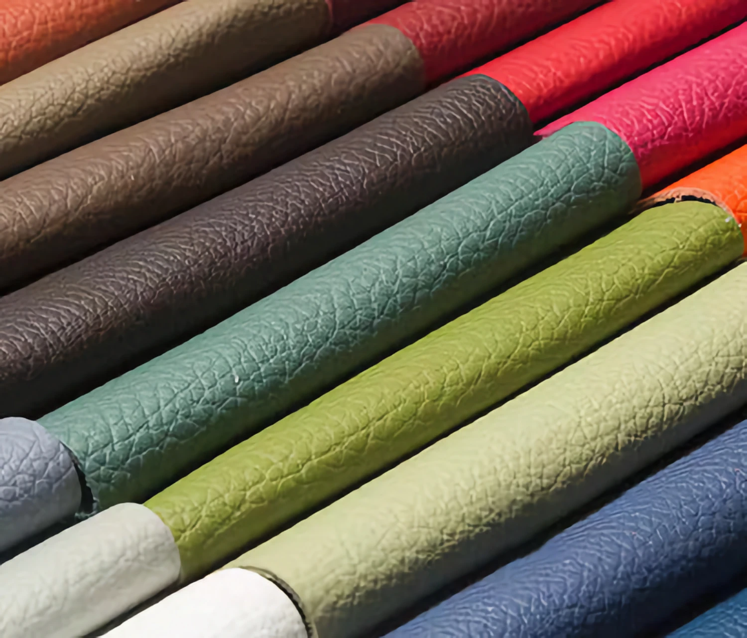 Many different colors of faux leather samples. These faux leather samples are neatly arranged to form a colorful array. Each artificial leather sample has its own unique color and texture, giving a colorful feeling. The whole scene presents an artistic and creative atmosphere.