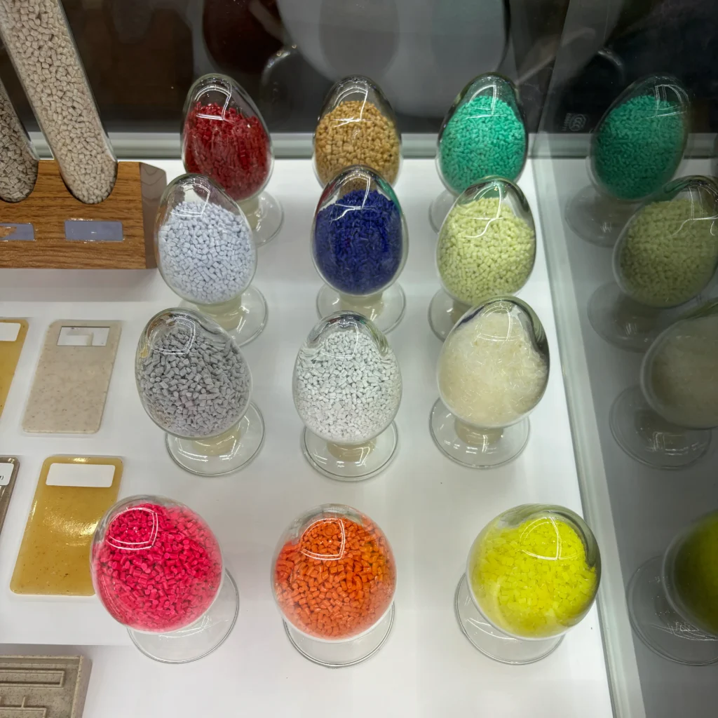A variety of colors of EVA masterbatch granular material, these granules are placed in 12 glass vials, each containing a different color. From left to right and top to bottom, these colors are, in order, light brown, red, yellow, green, blue, white, gray, beige, pink, orange and yellow.